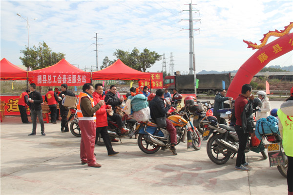 圖為藤縣總工會(huì)在省道304線藤縣陶瓷工業(yè)園區(qū)商業(yè)街小廣場設(shè)立藤縣總工會(huì)為農(nóng)民工平安返鄉(xiāng)“暖流行動(dòng)”服務(wù)站，積極為騎摩托車